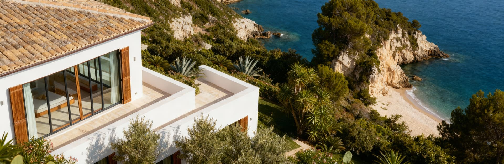 Elegante villa di lusso all'Argentario vista aerea, circondata da vegetazione lussureggiante e affacciata su calette nascoste.
