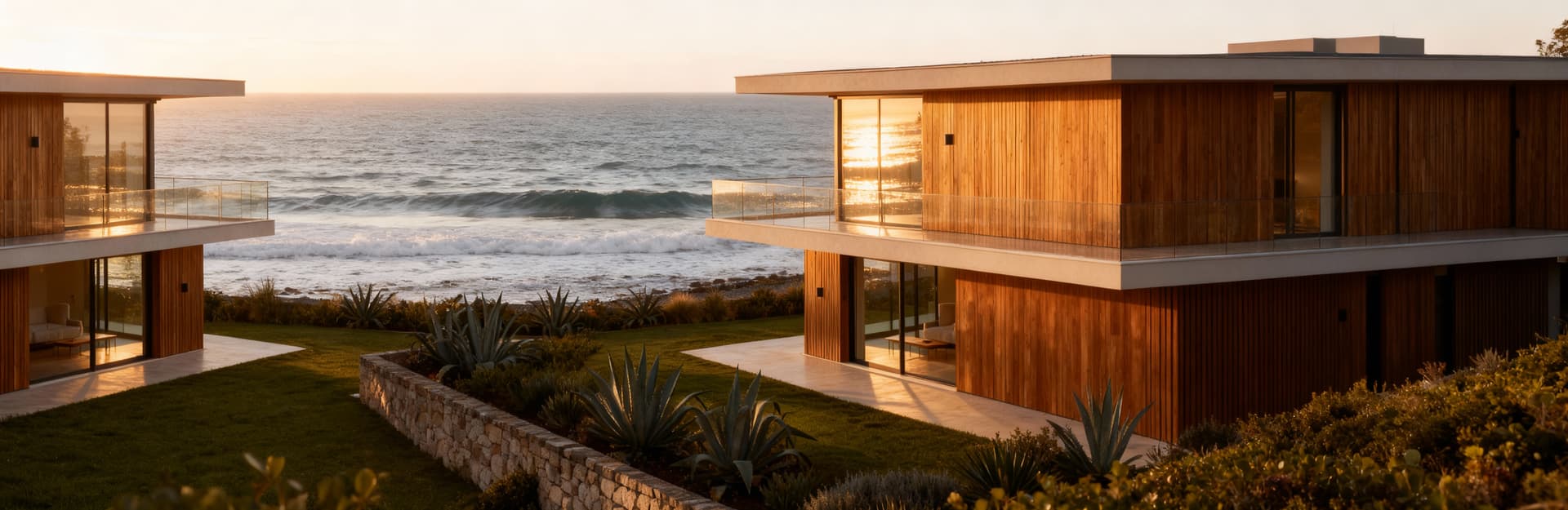 Villa moderna affacciata sul mare a Livorno, circondata da piante mediterranee e illuminata dalla luce del tardo pomeriggio.