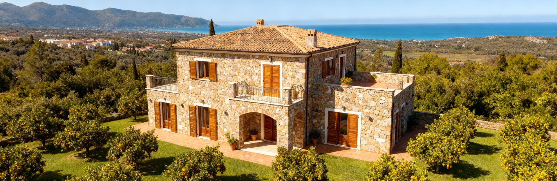 Elegante villa in Calabria con vista sulle montagne della Sila e mare Tirreno, circondata da un giardino con agrumi.
