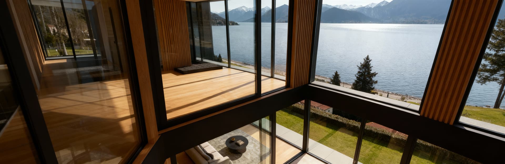 Appartamento moderno in vendita a Lugano, vista lago e Alpi, ampie vetrate, eleganti materiali in legno e vetro.