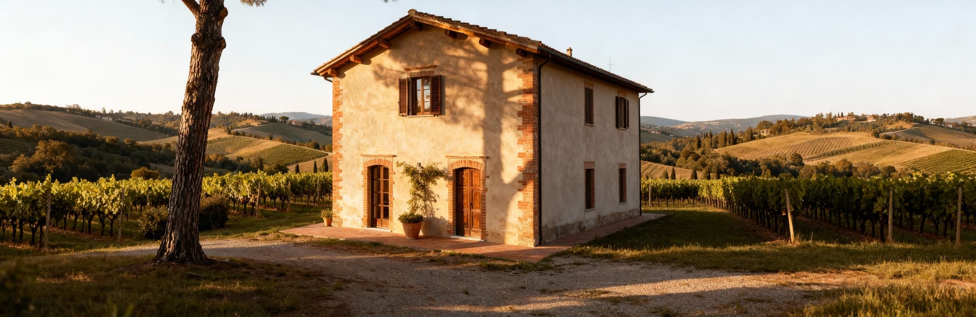 Terratetto storico in Toscana tra colline e vigneti, con travi in legno e mattoni a vista, illuminato dalla luce del mattino.