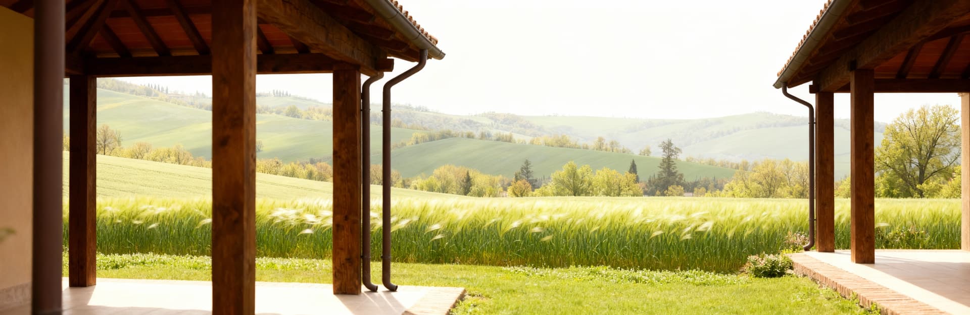 Rustico in vendita in provincia di Forlì-Cesena, con struttura in legno, tetto in tegole e colline verdi sullo sfondo.