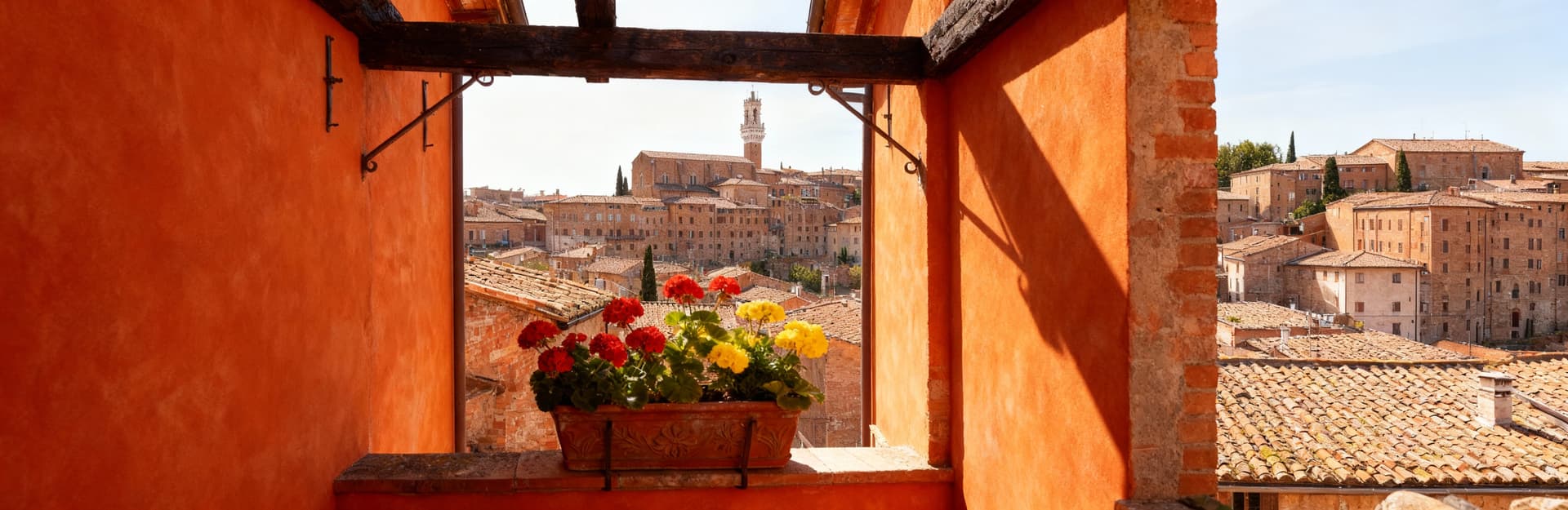 Charming townhouses for sale in Siena, Tuscany, surrounded by lush hills, vineyards, and historic architecture.