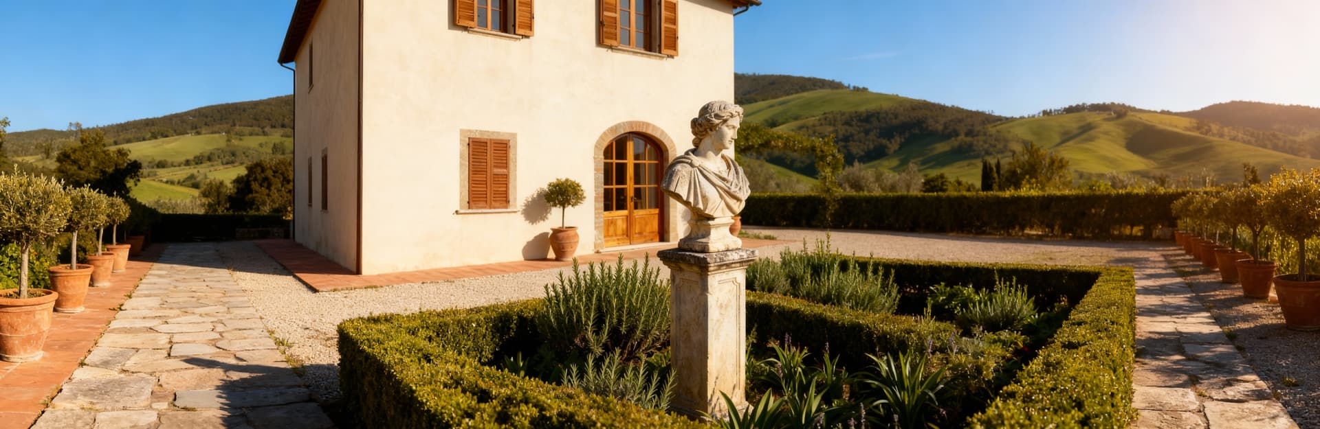 Elegante casale toscano nel Chianti con giardino curato, statue di pietra e dolci colline sullo sfondo.