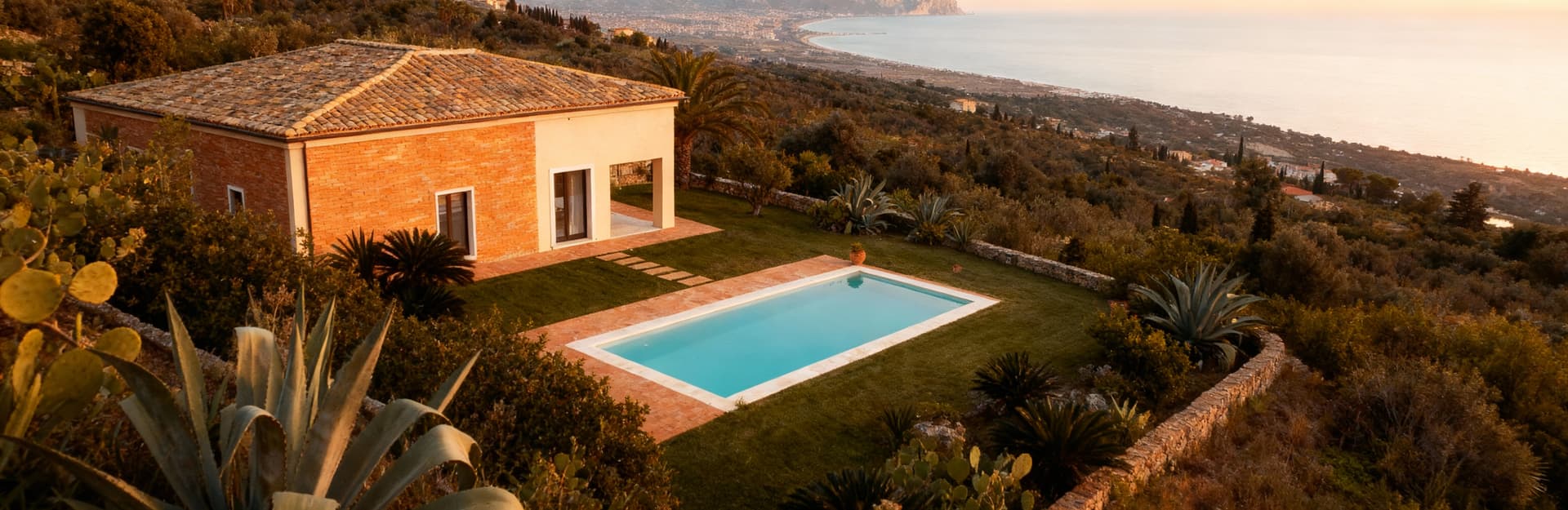 Villa con piscina a Messina, immersa nel paesaggio siciliano, con vista sullo Stretto e giardino di piante locali.