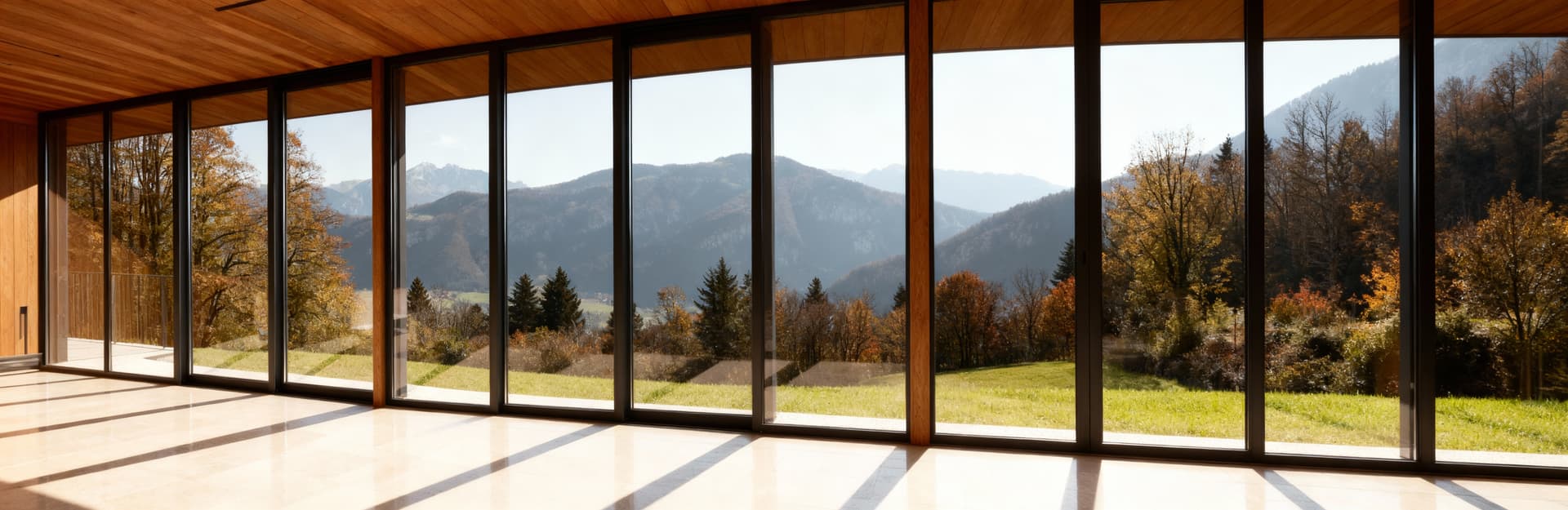 Villino moderno a Pordenone con ampie vetrate che si affacciano su un paesaggio montano, materiali legno e vetro.