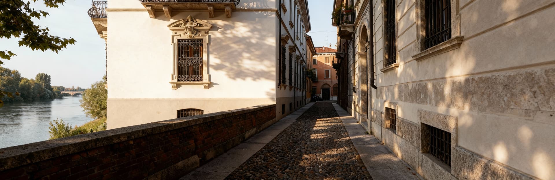 Elegante palazzo in intonaco chiaro nel centro storico di Pavia, tra strade acciottolate e il fiume Ticino.