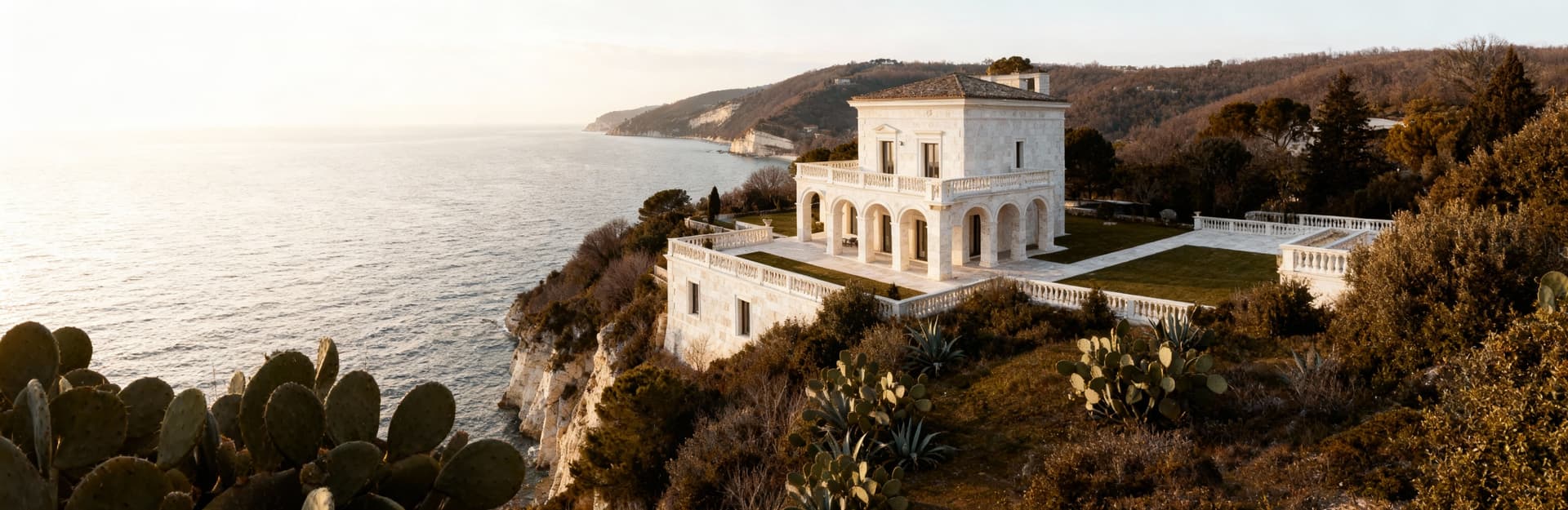 Elegante villa con vista mare ad Ancona, architettura in travertino bianco, illuminata da dolce luce invernale.