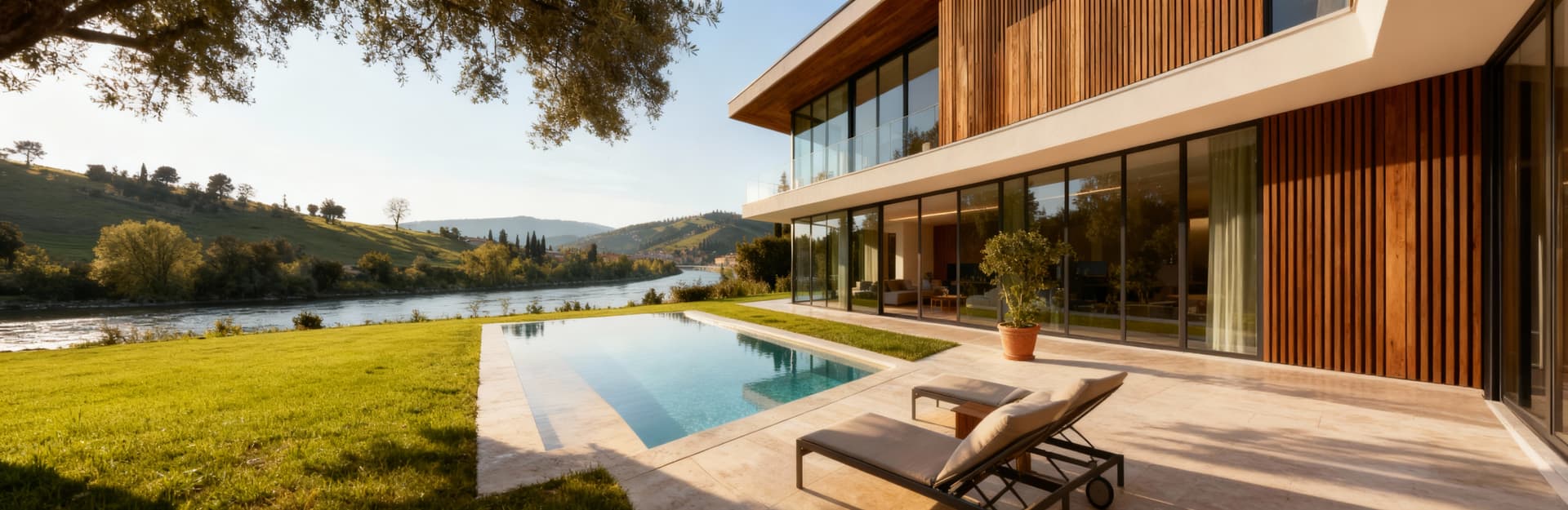 Villa moderna a Verona con facciate in vetro e legno, circondata da giardino e piscina, panorami del fiume Adige e colline.