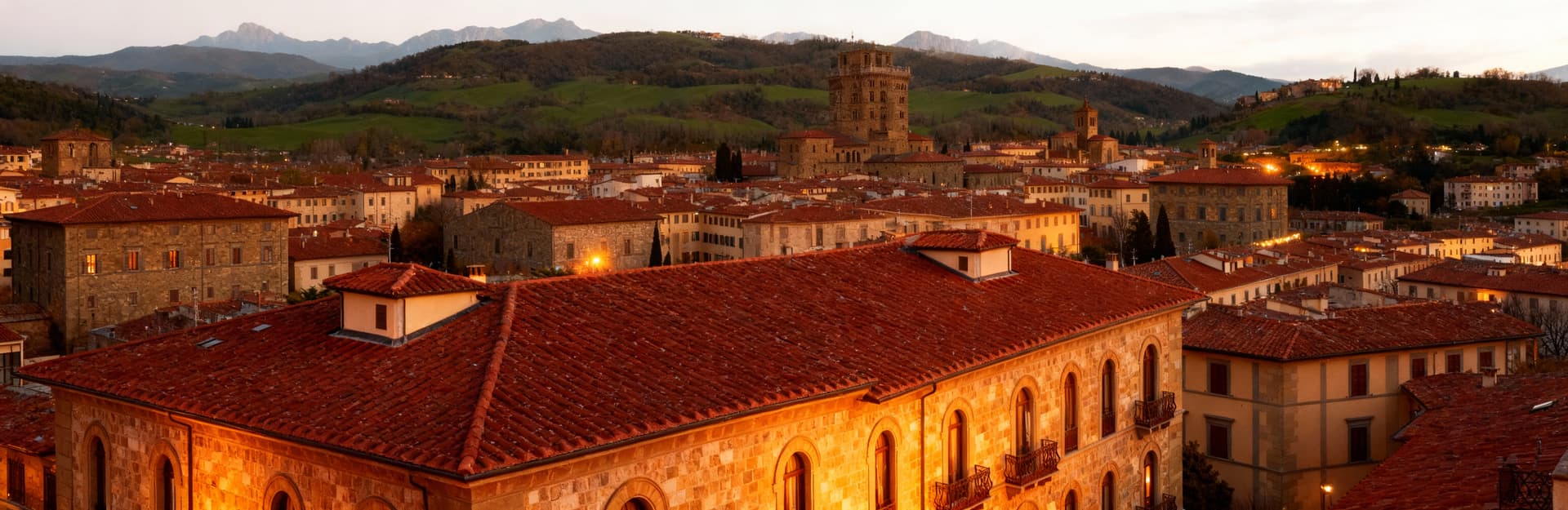 Vista panoramica di appartamenti in vendita a Prato, con eleganti facciate in pietra e colline verdi sullo sfondo.