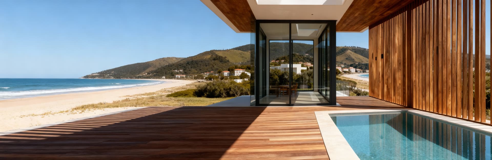 Villa moderna a Pescara con piscina a sfioro e vista mare, caratterizzata da ampie vetrate e dettagli in legno e vetro.