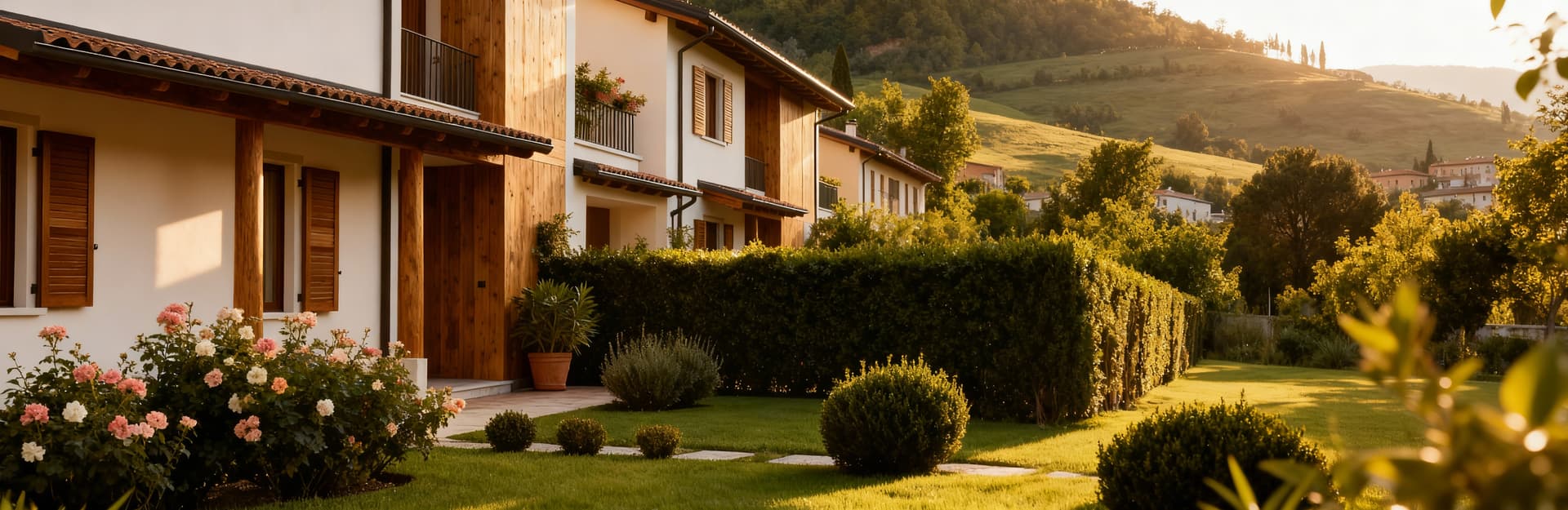 Villetta a schiera a Verona tra colline, con giardino curato e materiali naturali, illuminata da un pomeriggio sereno.