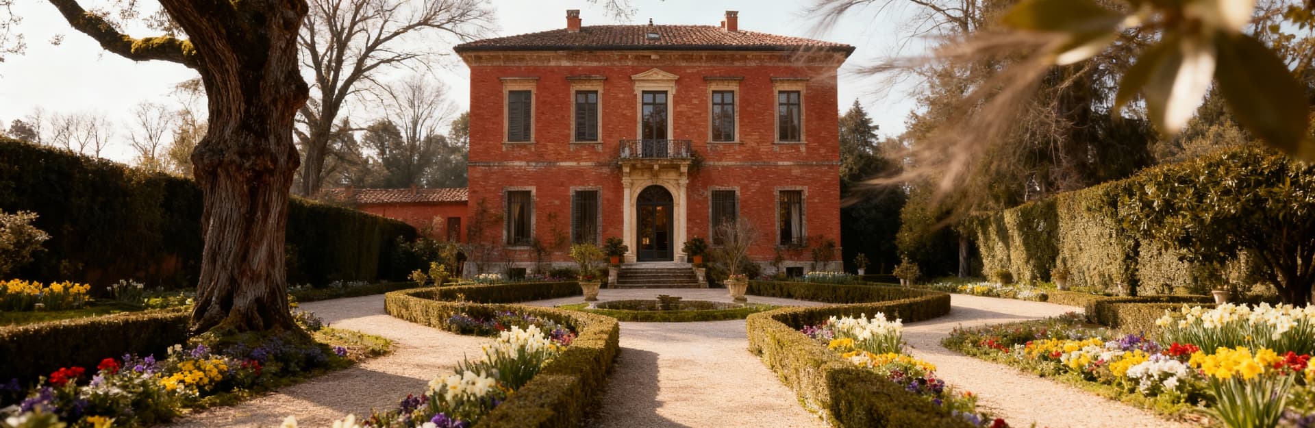 Elegante villa storica circondata da alberi secolari e aiuole fiorite, tipica architettura piemontese in luce invernale.
