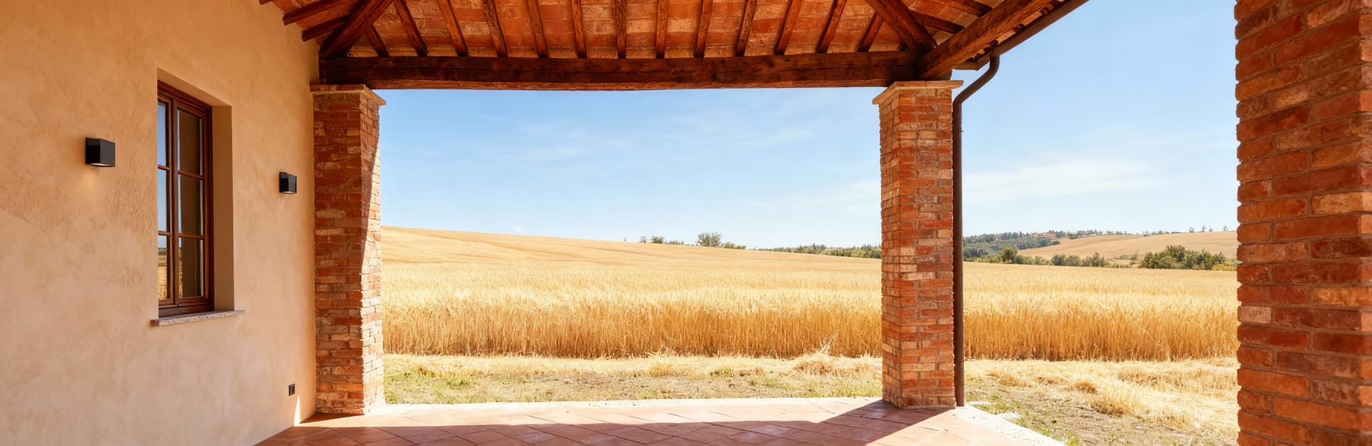 Appartamenti di lusso in vendita in Emilia Romagna, casale rustico circondato da campi di grano e cielo sereno.