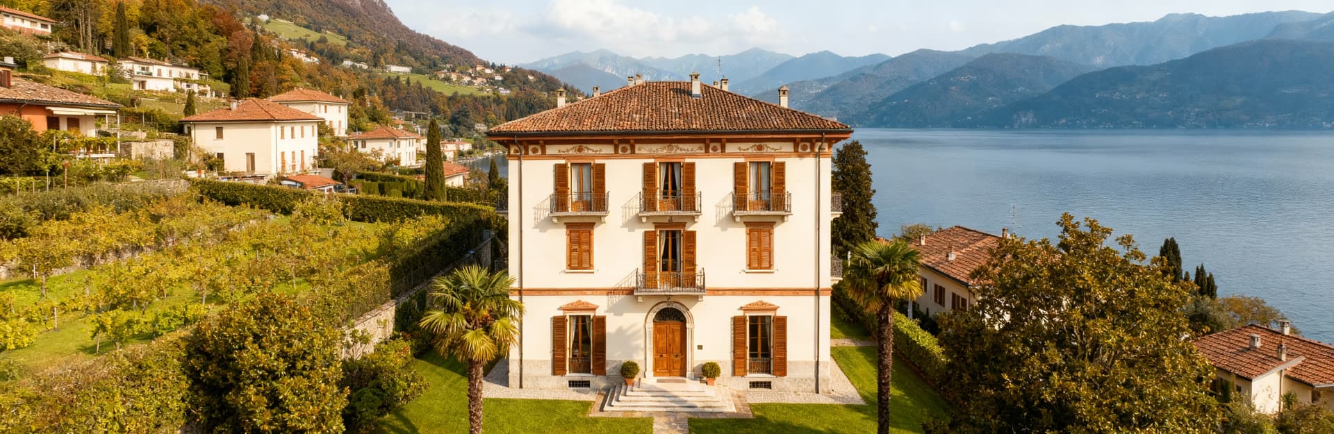 Appartamenti in villa in vendita in Lombardia, circondati da giardini, con facciata chiara e vista su laghi e colline.