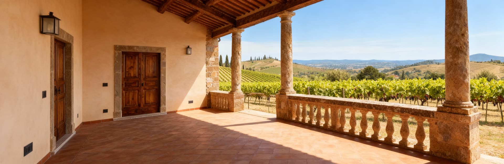 Colonica in pietra nel Chianti circondata da vigneti, con interni in legno e cotto, e un panorama collinare sotto un cielo blu.