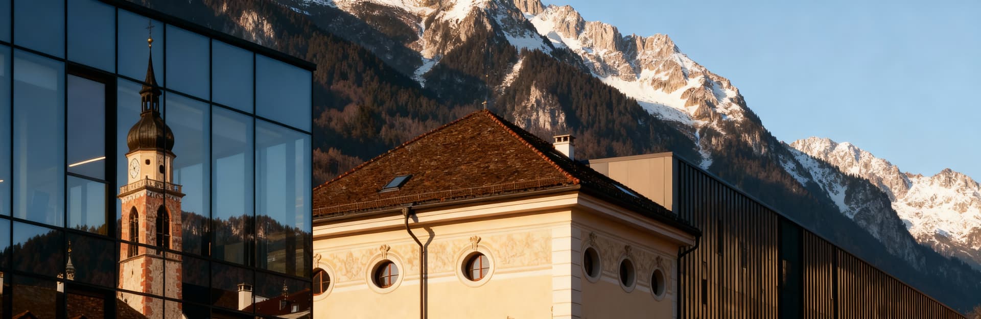 Uffici moderni in vendita a Bolzano, con vista sulle Dolomiti e dettagli architettonici in luce del tardo pomeriggio.