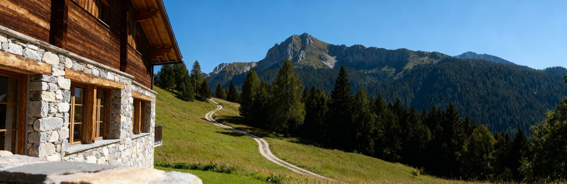 Elegante rifugio di montagna a Madonna di Campiglio, design in legno e pietra in un paesaggio naturale sereno.