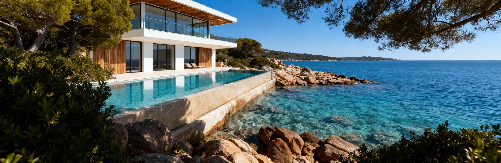 Lussuosa villa con piscina sulla Costa Smeralda, incastonata tra scogliere, cielo blu e acque cristalline.
