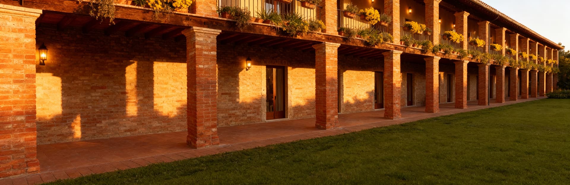 Terratetto in Lazio con muri in mattoni, travi in legno e balconi fioriti, immerso in una luce calda del tardo pomeriggio.