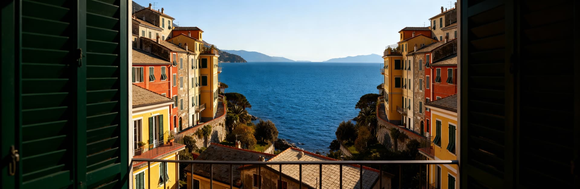 Appartamenti in vendita all'Isola d'Elba con vista sul Golfo dei Poeti, luce mattutina su facciate colorate e mare blu.