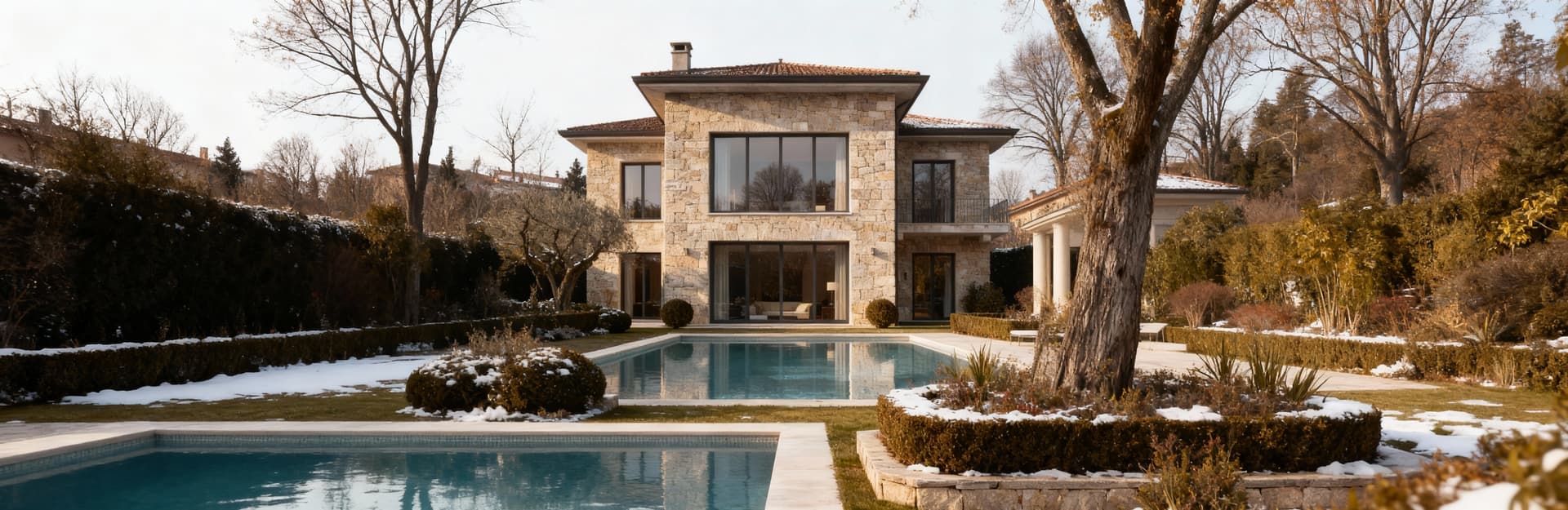 Elegante villa in vendita a Milano, circondata da giardini curati e piscine, con facciate in pietra e grandi vetrate.