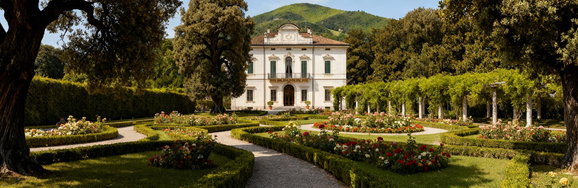 Villa storica a Gorizia affacciata su un giardino curato, con alberi secolari e facciata elegante in intonaco chiaro.