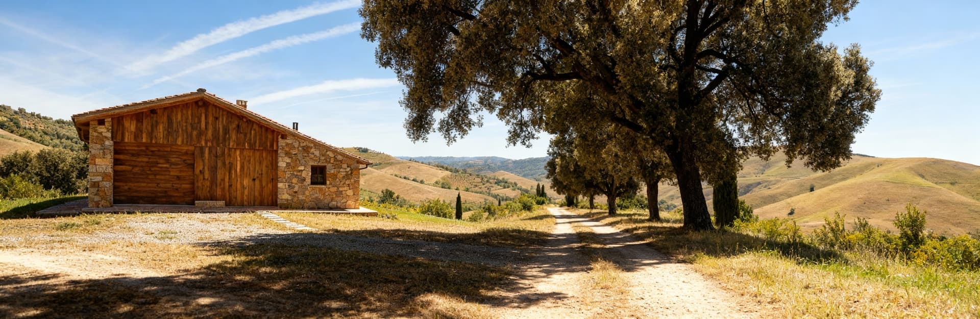 Rustico in legno e pietra tra dolci colline, cielo blu con nuvole bianche, luce naturale che esalta il paesaggio toscano.