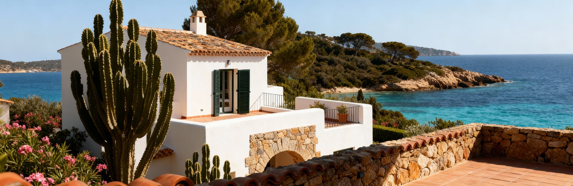 Appartamenti di lusso in vendita a Porto Cervo, circondati dalla vegetazione mediterranea e vista mare, eleganti terrazze e giardini privati.