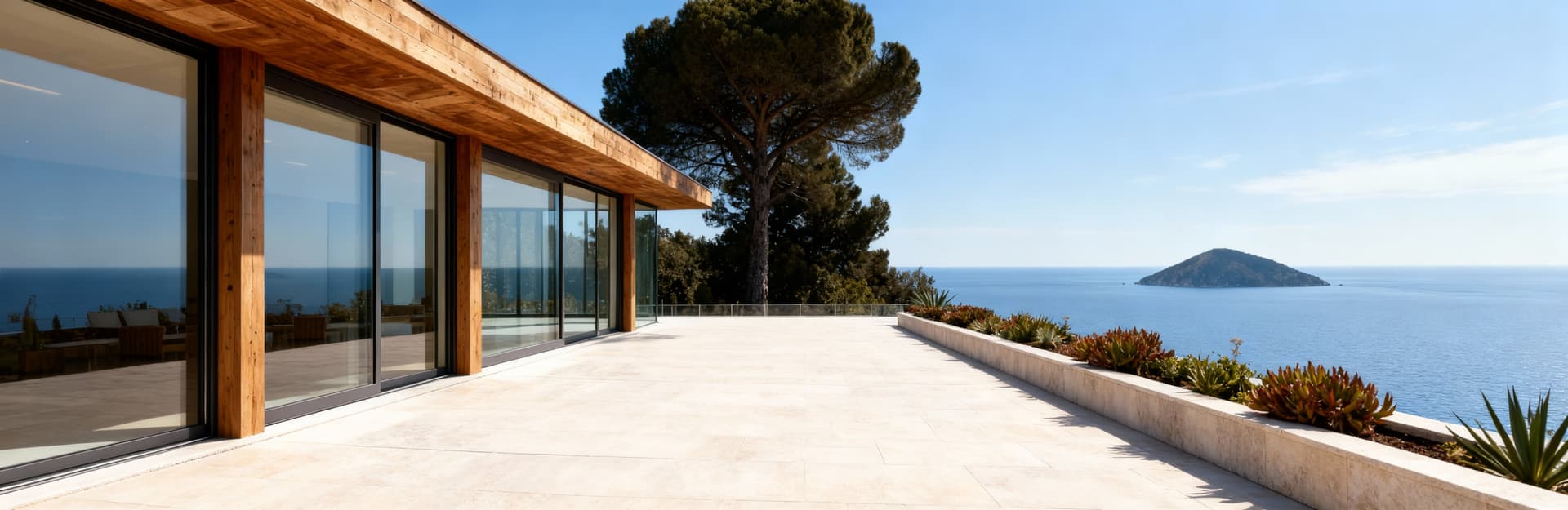 Terrazza panoramica su villa moderna con vetrate, affacciata sul Golfo dei Poeti, circondata da piante e cielo blu.