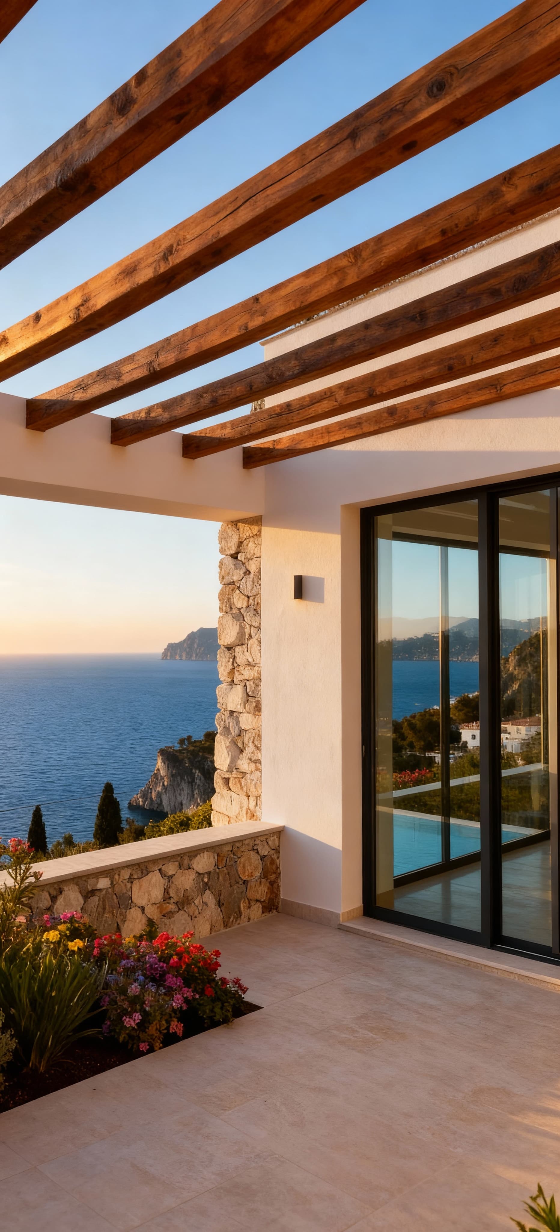 Villa di lusso con vista sulla costa amalfitana, ampie vetrate, dettagli in pietra e giardino fiorito, atmosfera serena.