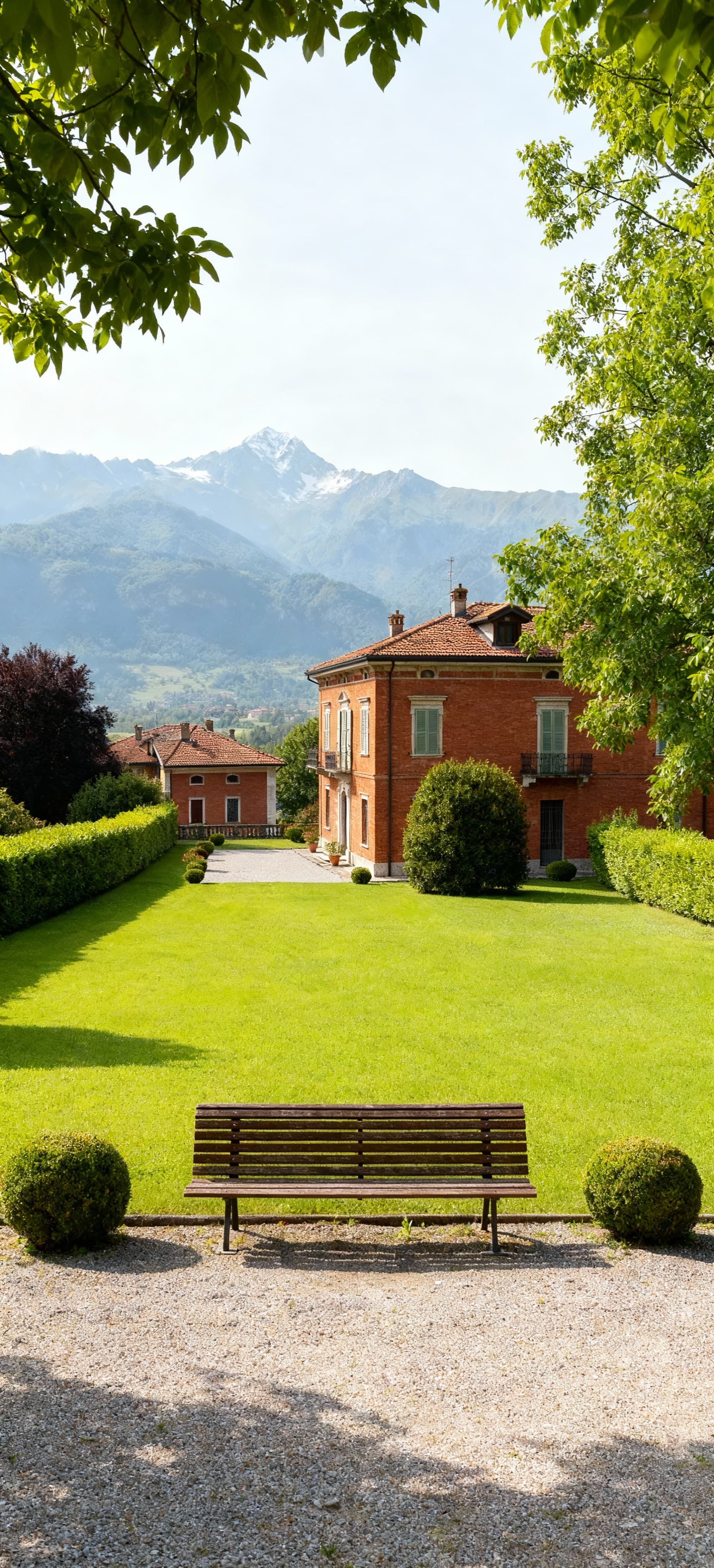 Immobili di prestigio a Cuneo, eleganti ville circondate da giardini verdi e panorama alpino nel cielo sereno.