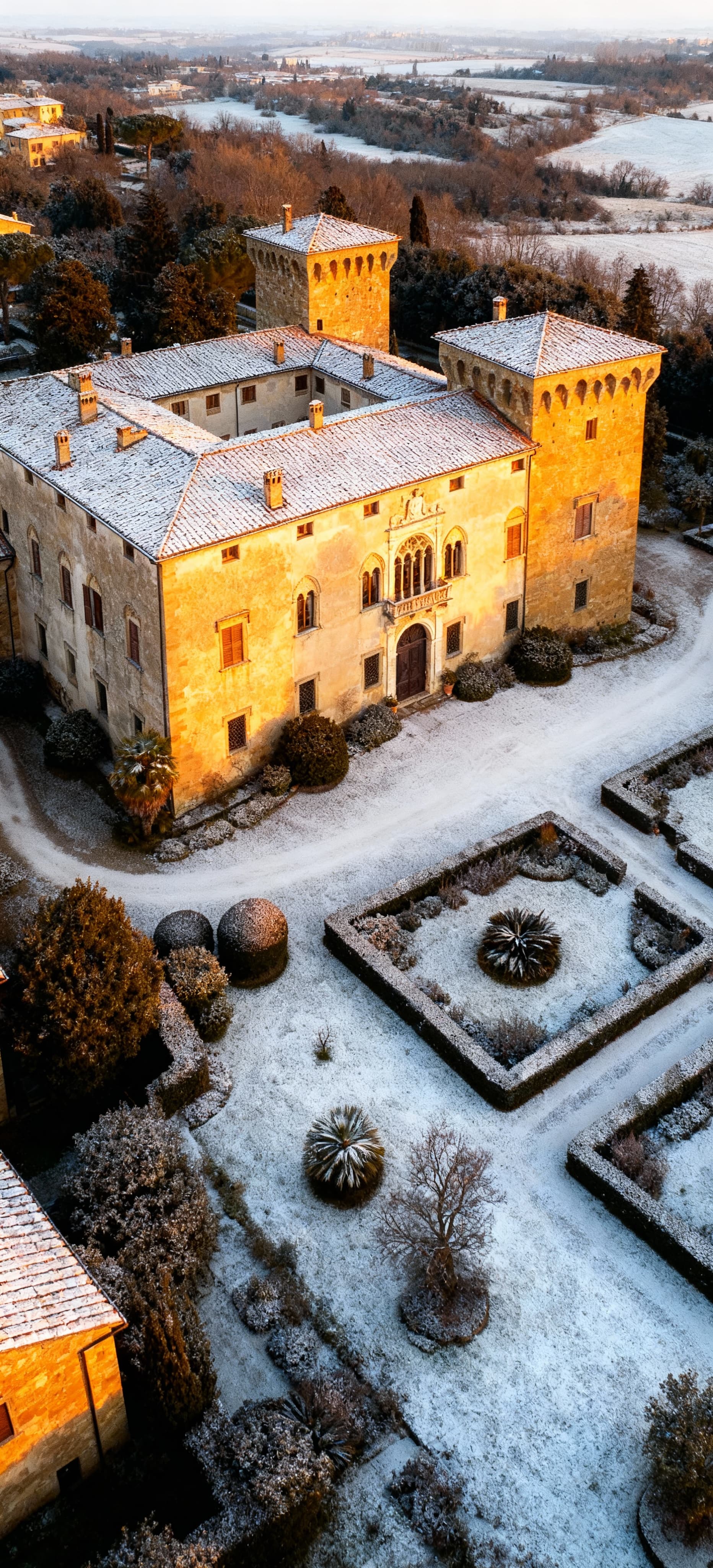 Castello elegante a Prato immerso in una luce invernale, circondato da giardini lussureggianti e dettagli architettonici storici.