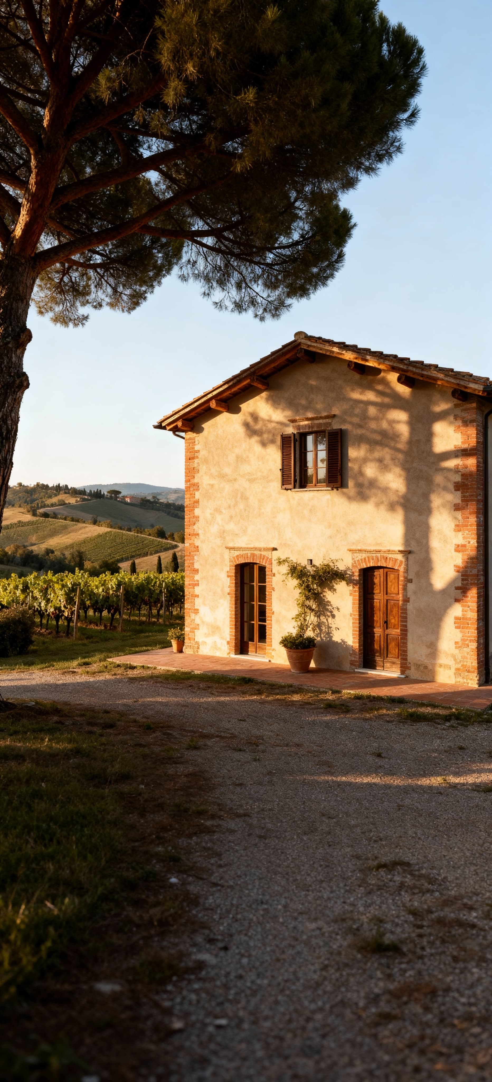 Terratetto storico in Toscana tra colline e vigneti, con travi in legno e mattoni a vista, illuminato dalla luce del mattino.