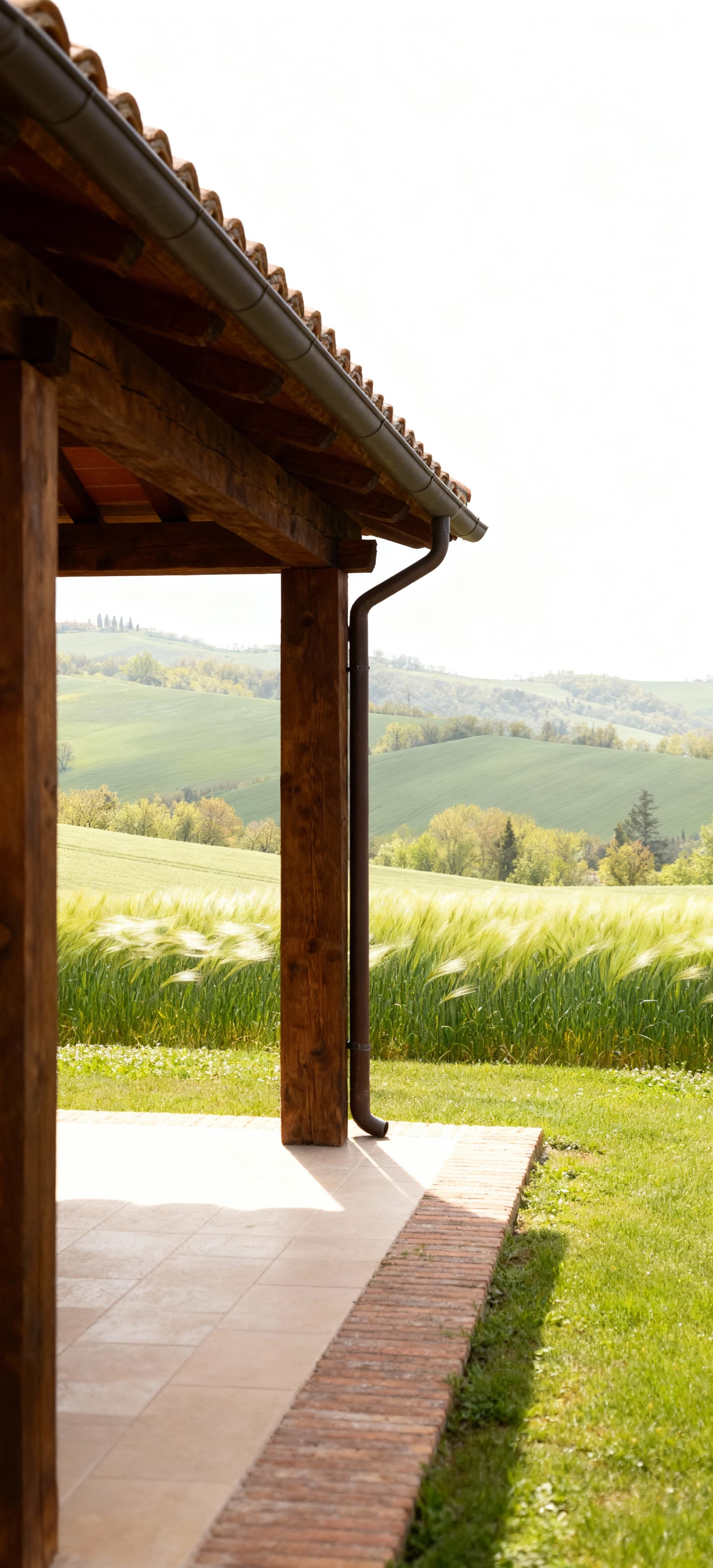 Rustico in vendita in provincia di Forlì-Cesena, con struttura in legno, tetto in tegole e colline verdi sullo sfondo.