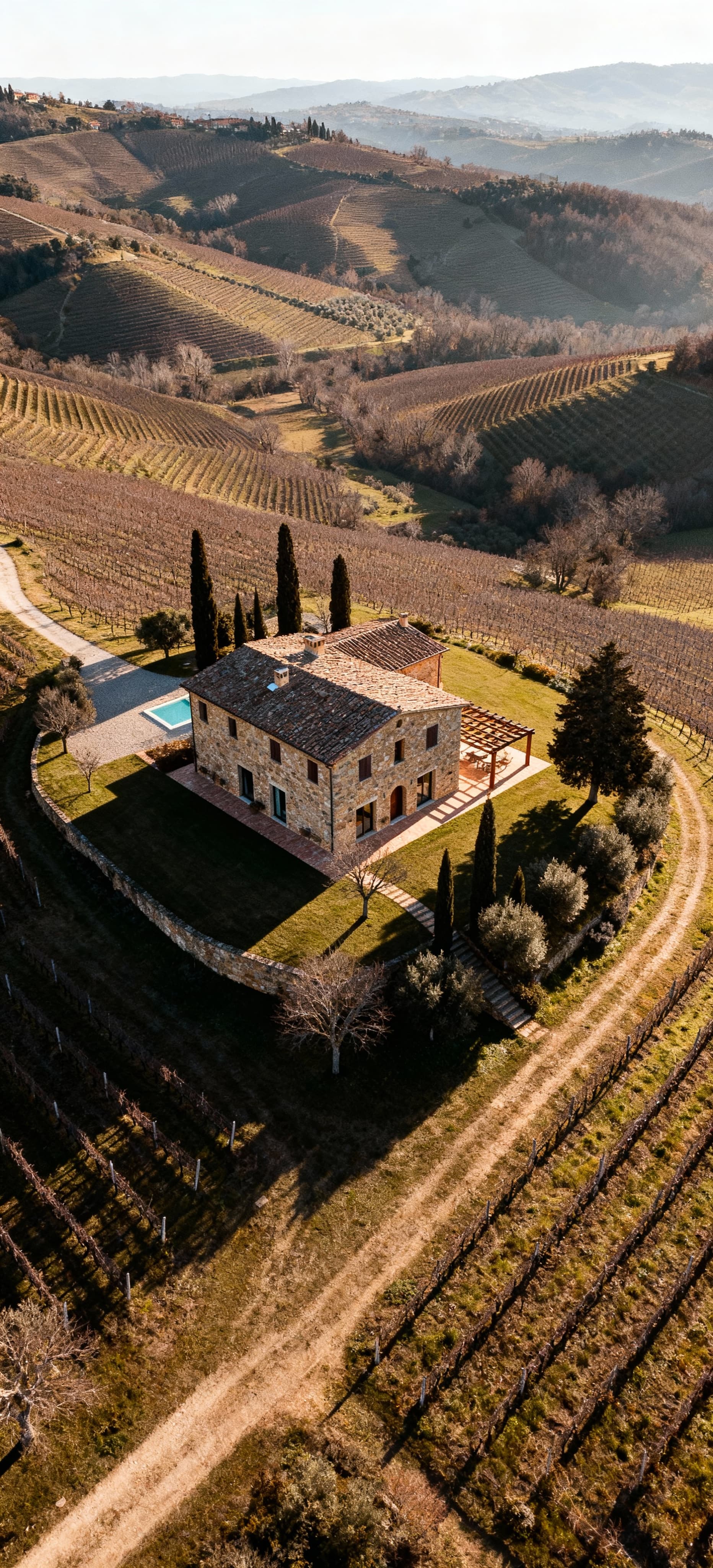 Luxury villas for sale in Chianti, surrounded by rolling hills and vineyards, featuring stunning sunsets and Chianti DOCG wine.