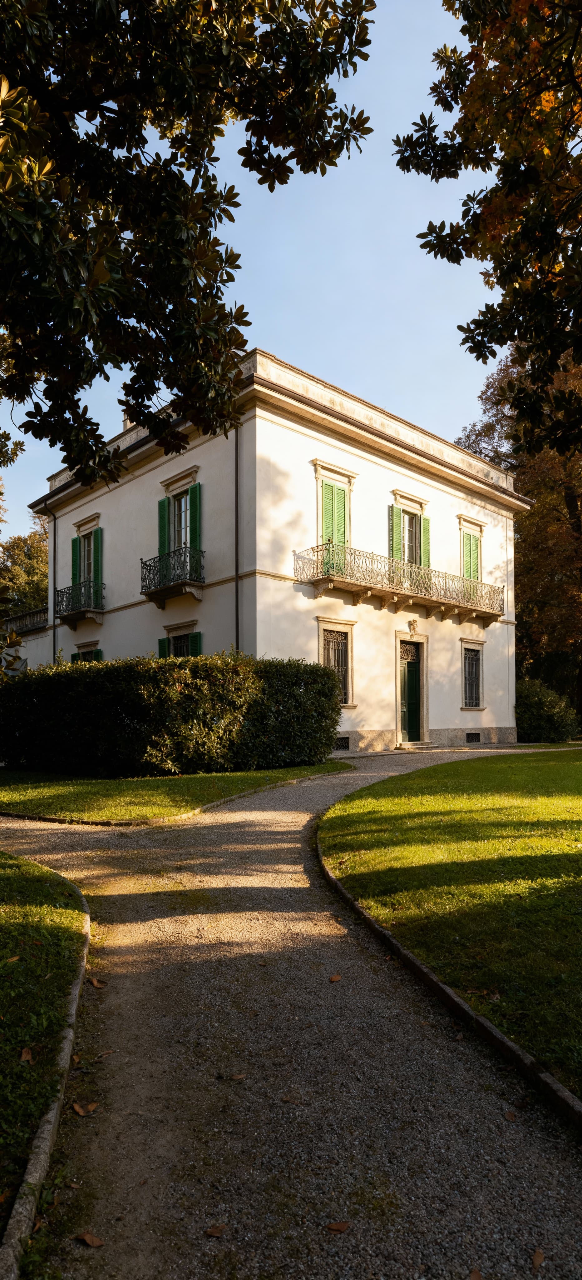 Villa storica in vendita a Padova, circondata da un parco lussureggiante con giardini illuminati dalla luce del mattino.