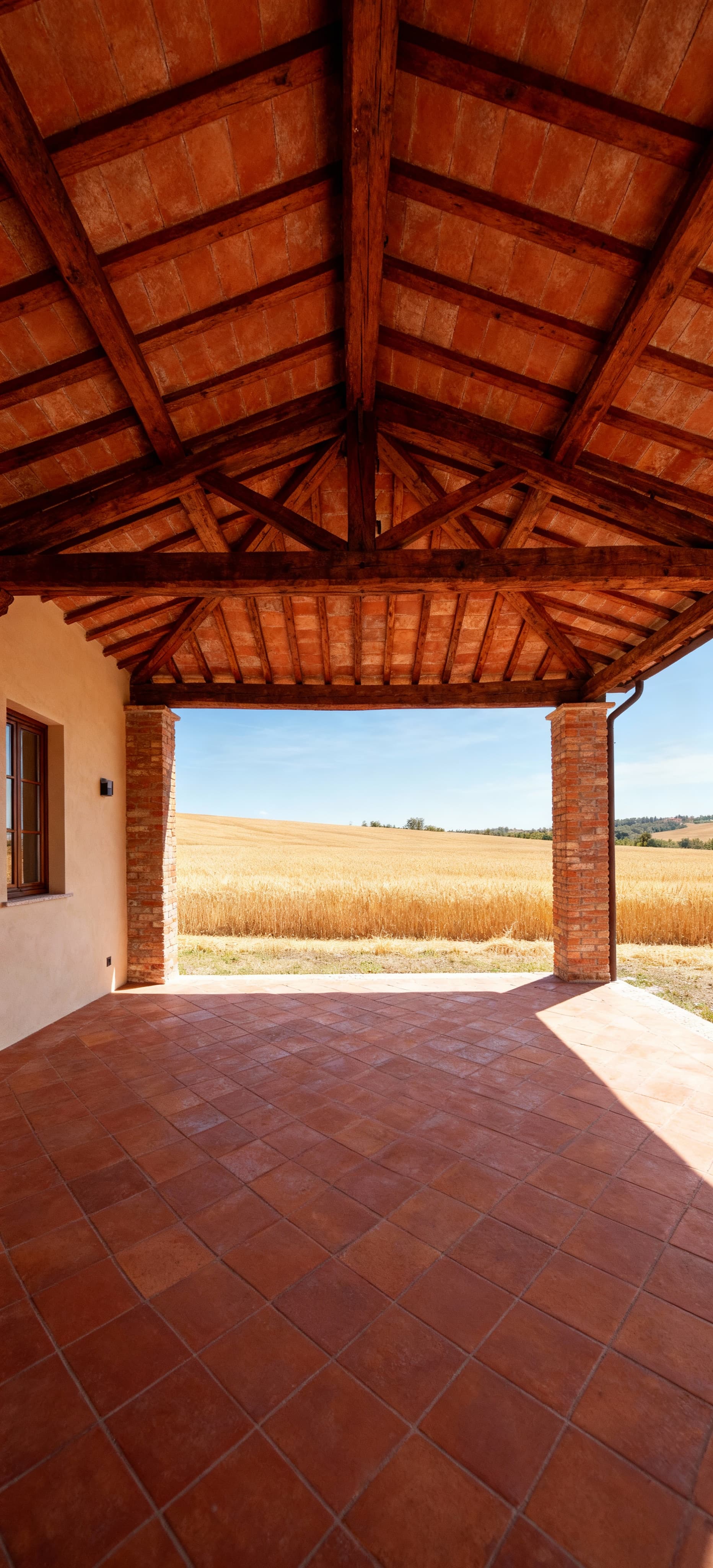 Appartamenti di lusso in vendita in Emilia Romagna, casale rustico circondato da campi di grano e cielo sereno.