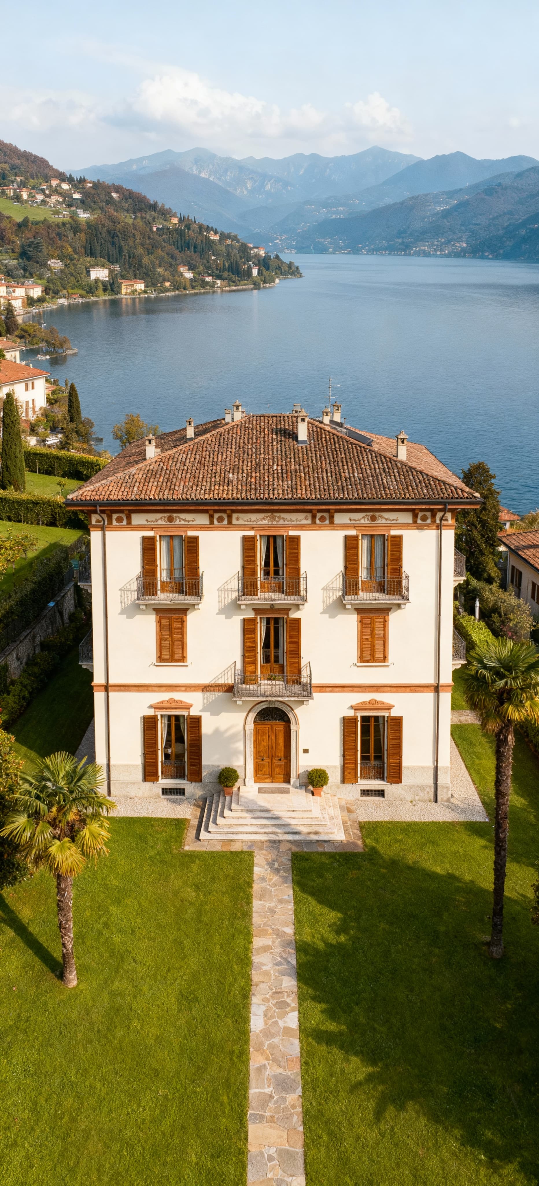 Appartamenti in villa in vendita in Lombardia, circondati da giardini, con facciata chiara e vista su laghi e colline.