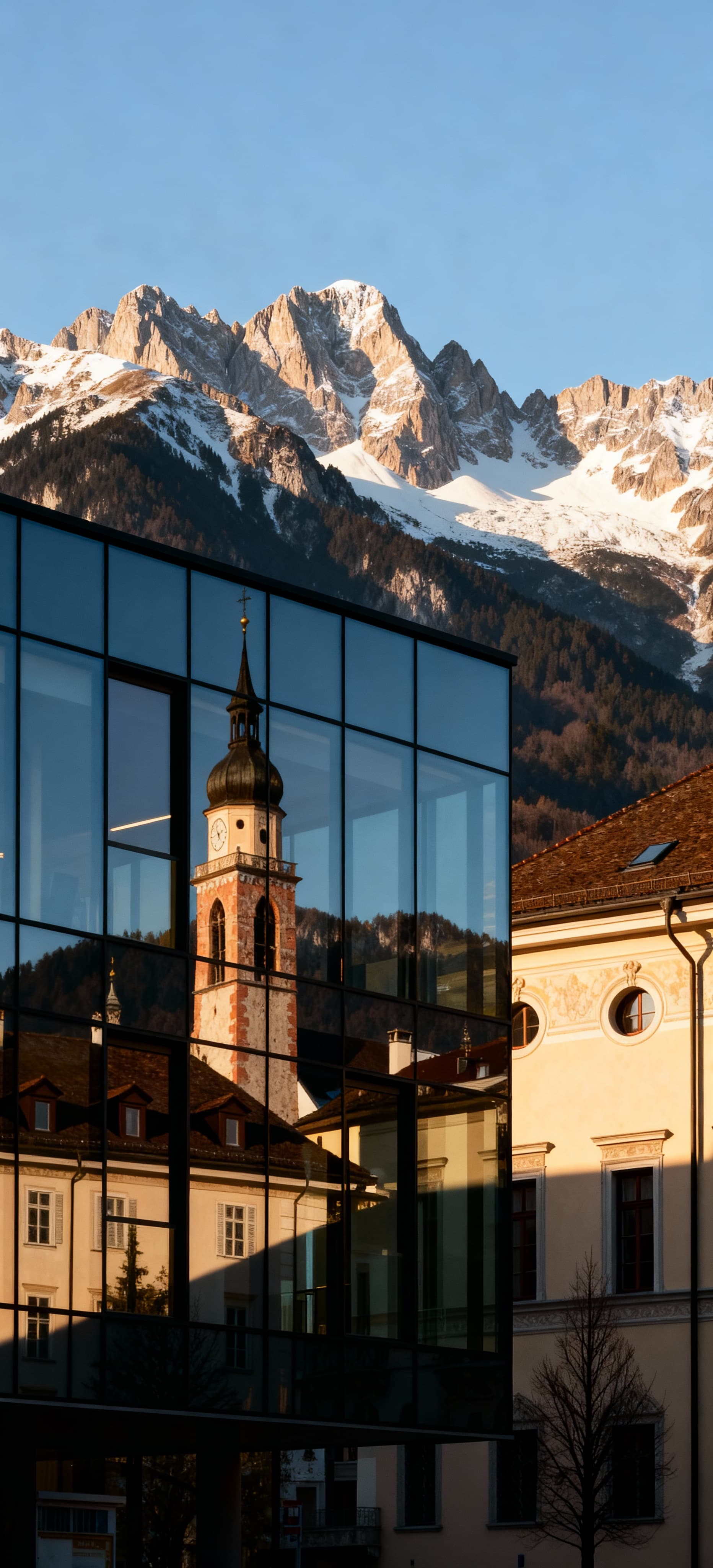 Uffici moderni in vendita a Bolzano, con vista sulle Dolomiti e dettagli architettonici in luce del tardo pomeriggio.