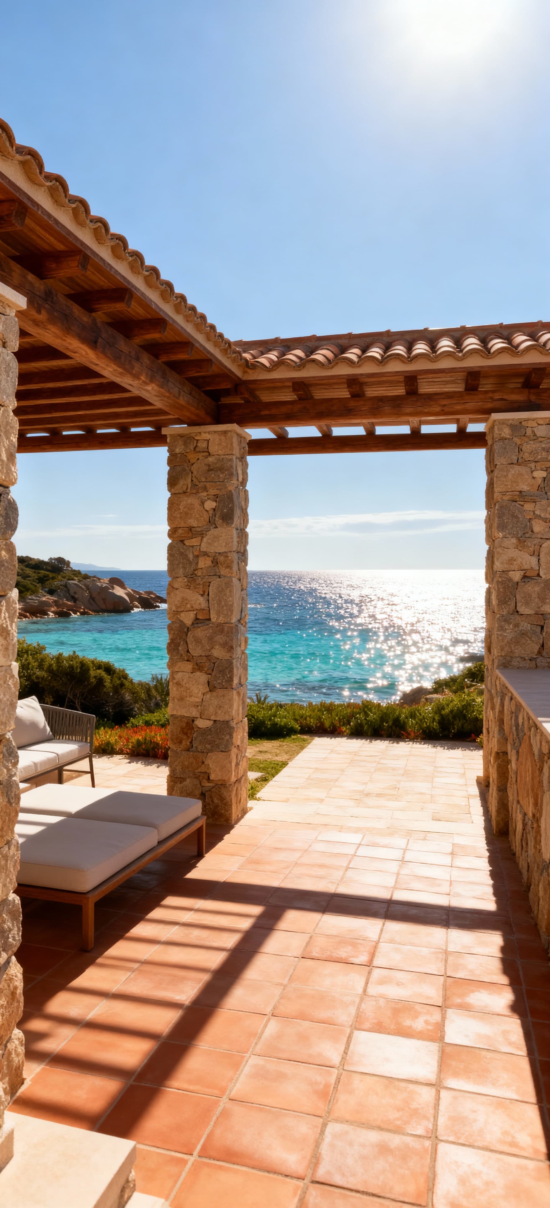 Villa elegante affacciata sul mare cristallino della Sardegna, con dettagli in pietra locale e legno naturale sotto un cielo sereno.