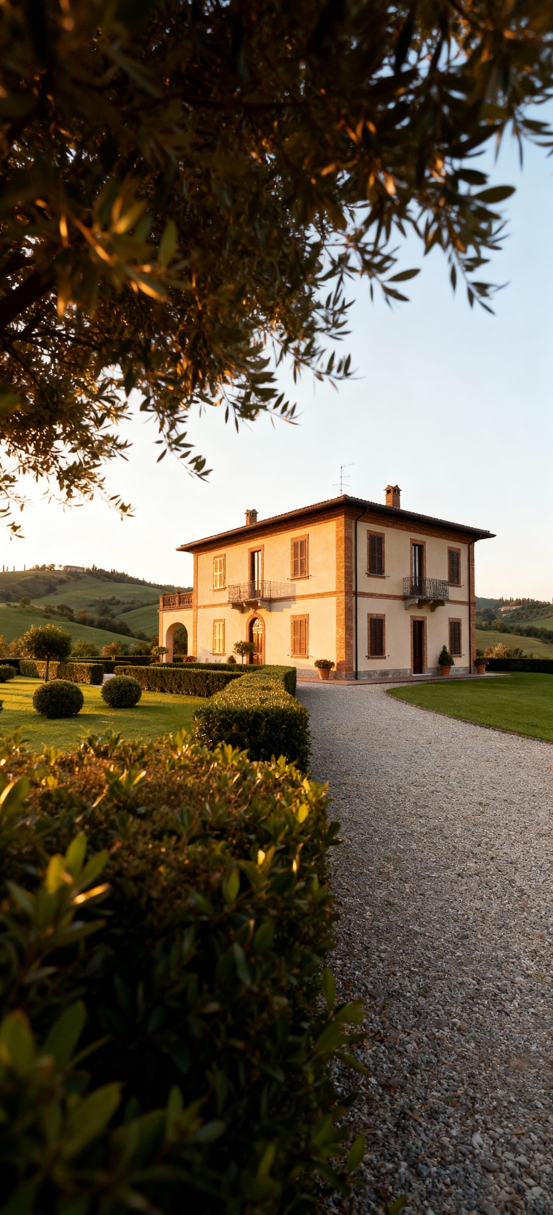 Tenuta di lusso in vendita in Sardegna, villa circondata da colline verdi e giardini curati, vista dal basso con luce pomeridiana.
