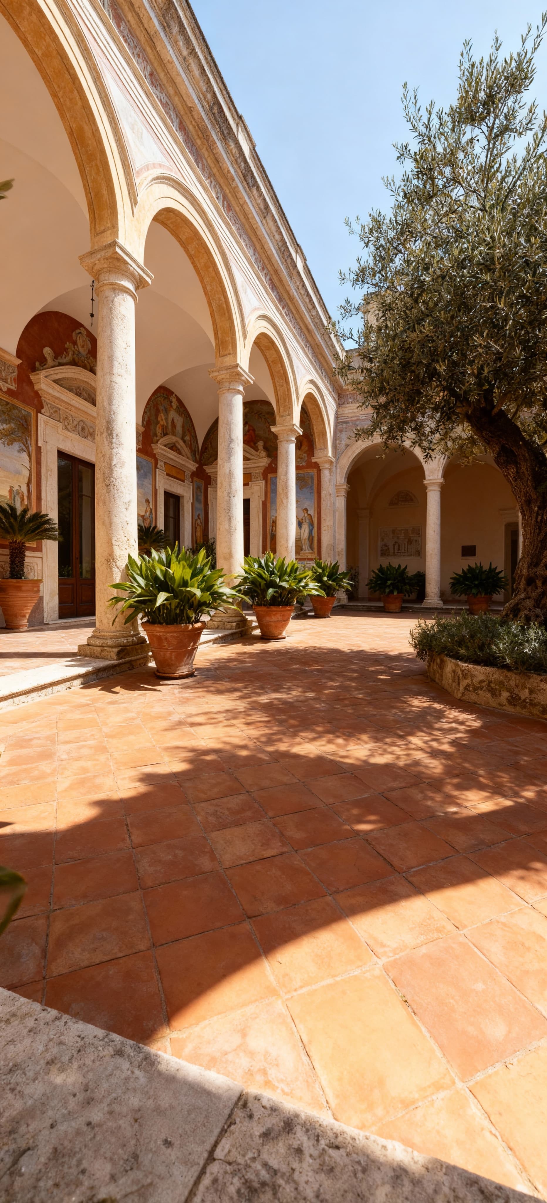 Villa storica a Barletta Andria Trani con affreschi e dettagli architettonici, cortile elegante con piante mediterranee.