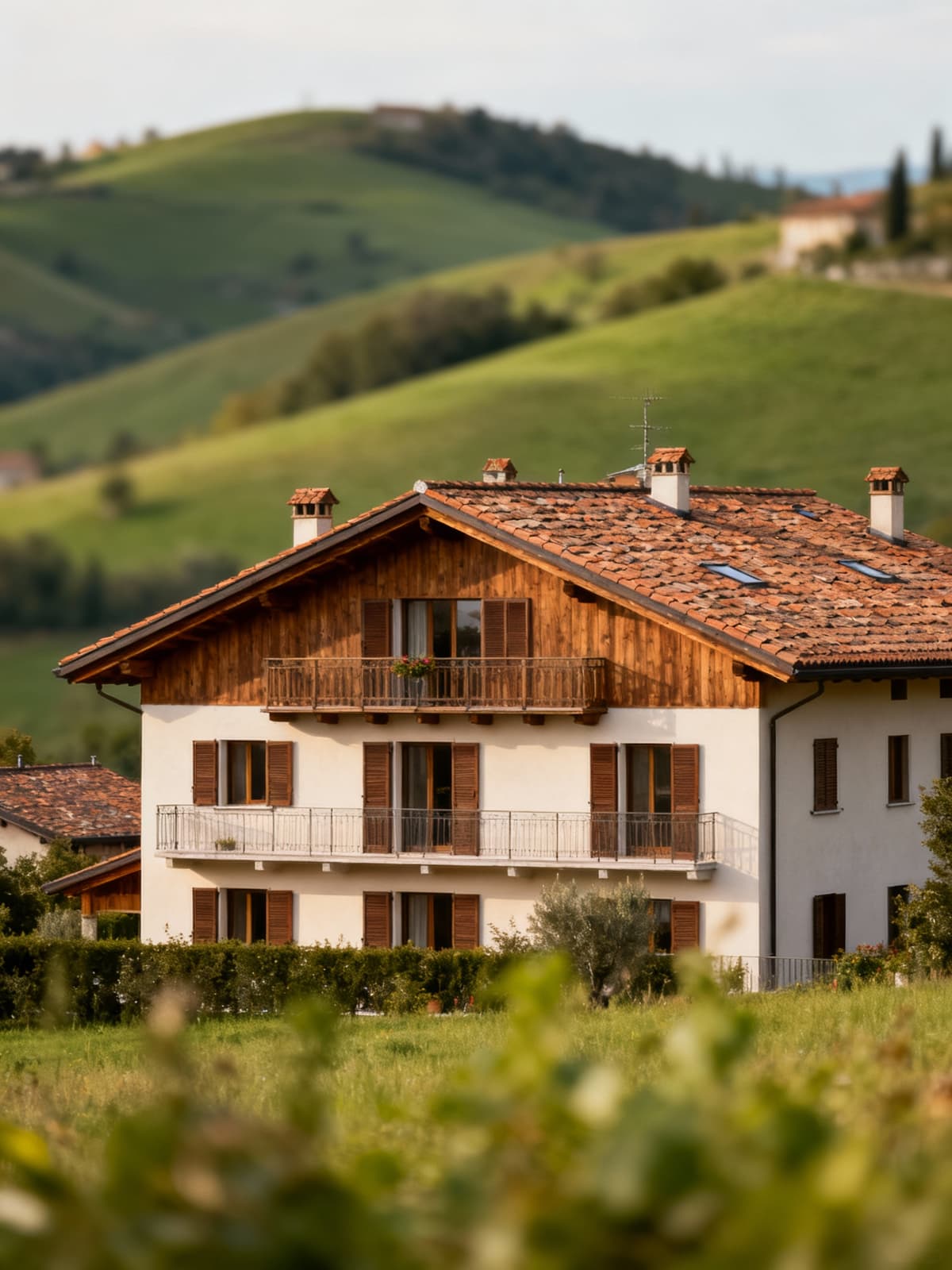 Appartamenti di lusso nella campagna bresciana, architettura tradizionale e materiali locali circondati da colline verdi.