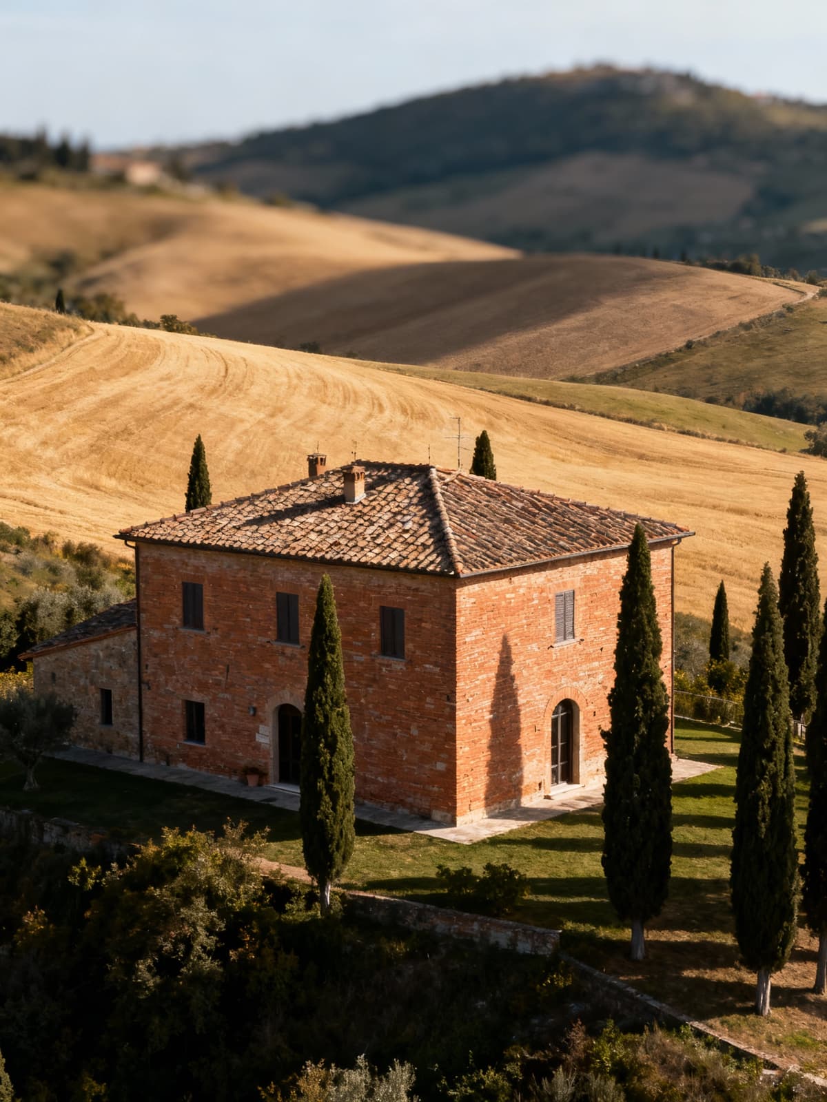 Casale toscano tra colline di Prato, con dettagli rustici e panorami di campi dorati e cipressi tradizionali.