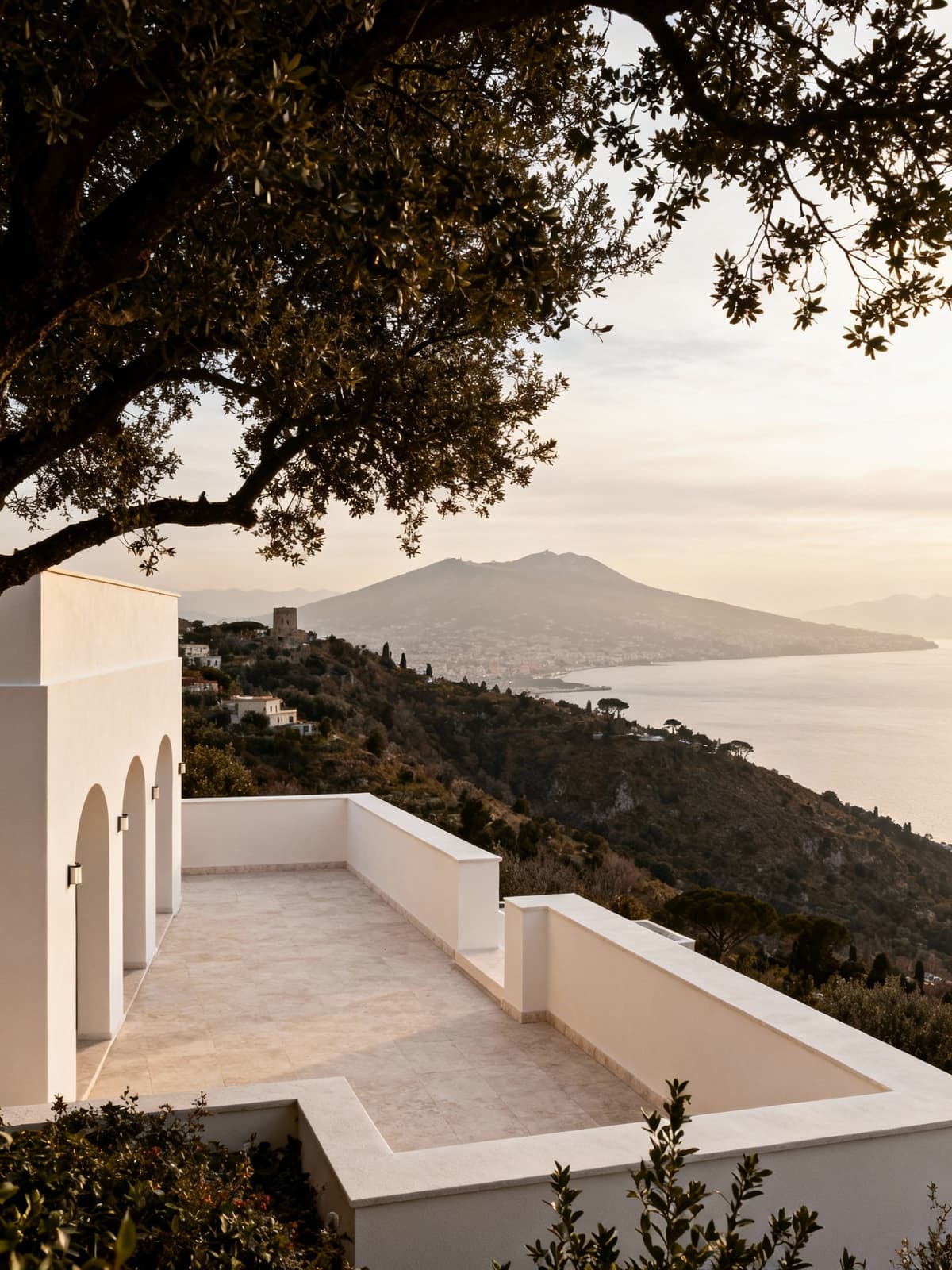 Albergo di lusso incastonato tra le colline campane, terrazza con vista sul Golfo di Napoli e luce invernale suggestiva.