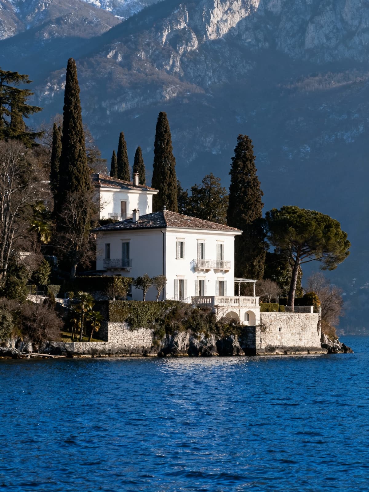Case di lusso indipendenti sul Lago di Garda, con facciate chiare e panorami naturali in un'atmosfera invernale serena.