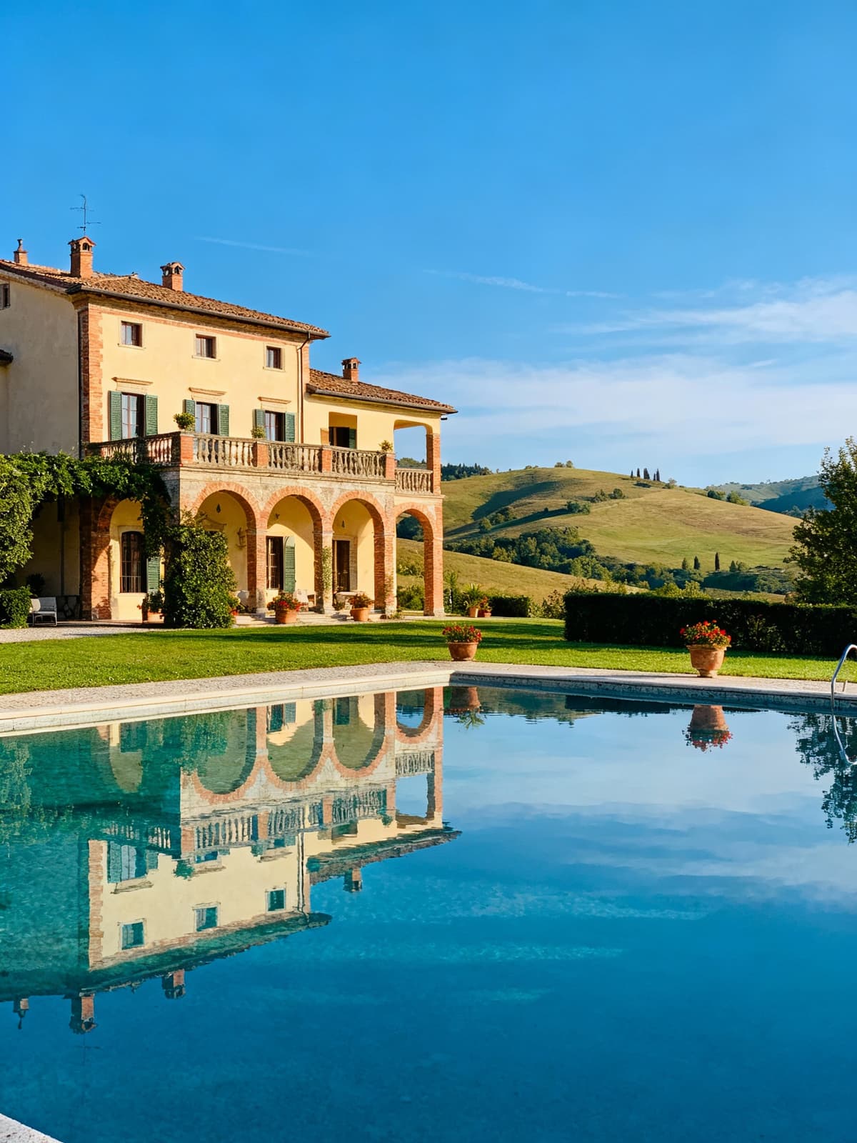 Villa esclusiva tra le colline di Reggio Emilia, con cielo sereno e dettagli architettonici che brillano nel blu.