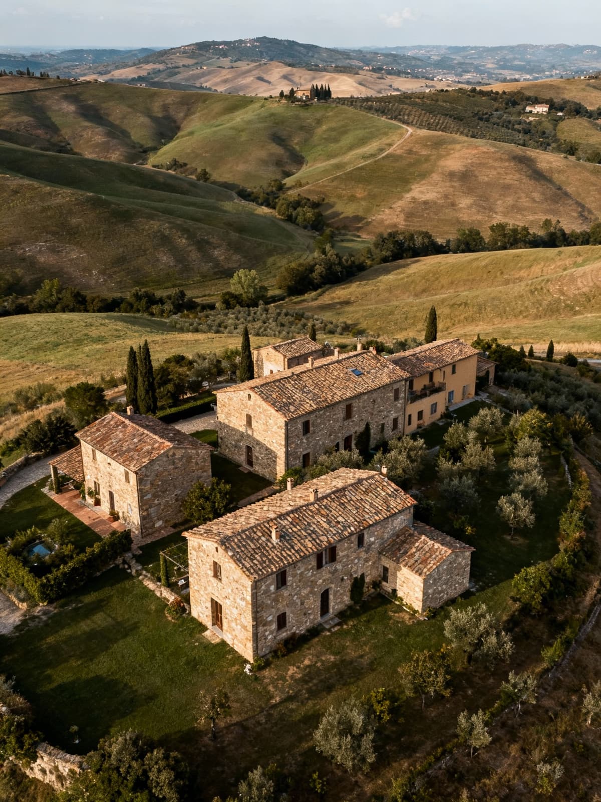Luxury agritourisms in the scenic Lucca countryside, featuring rustic structures amidst rolling hills and Tuscan traditions.