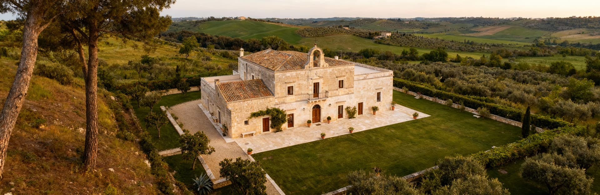 Masseria storica in Puglia immerse nel verde, con interni eleganti, sotto un cielo sereno e in un paesaggio idilliaco.